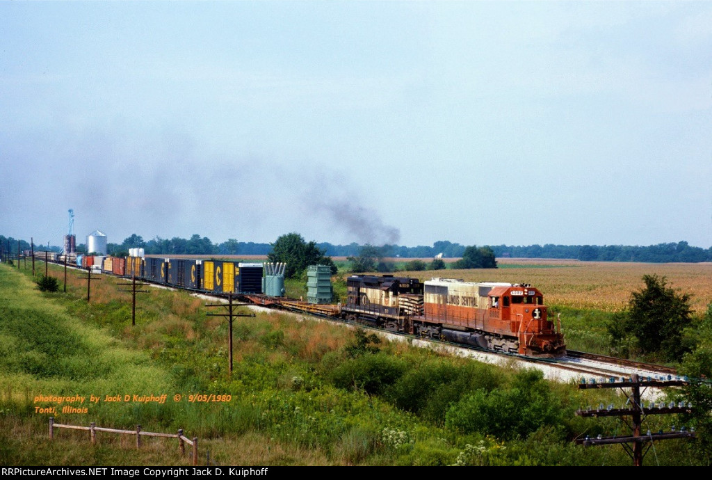 IC, Illinois Central SD40-2 6002-GM&O GP30 510, northbound and about to duck under I-57, at Tonti, Illinois. September 5, 1980.